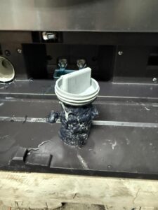 Drain filter housing with debris buildup inside a dishwasher base